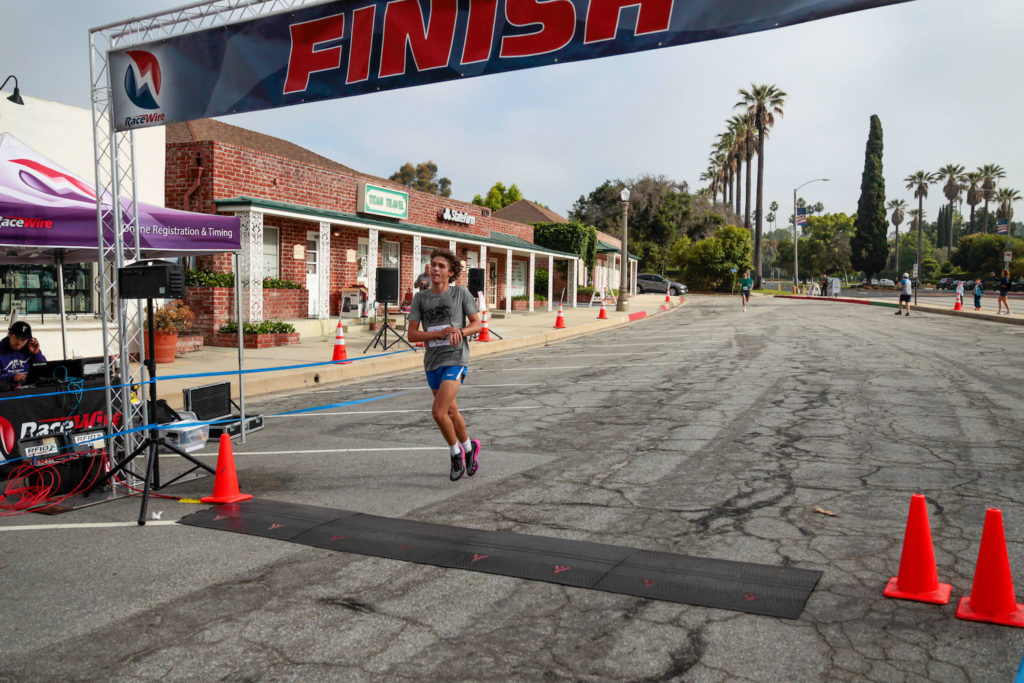 PHOTO: Mitch Lehman | San Marino Weekly | Benjamin Hughes crosses the finish line with a winning time of 16:18.